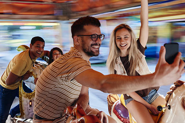 istock Happy friends taking a selfie during carousel ride at amusement park. 2224204470