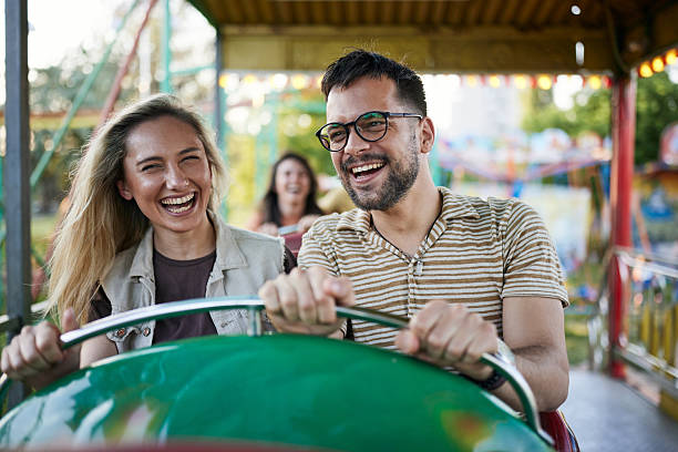istock Happy couple having fun while riding on rollercoaster at amusement park. 2224204692