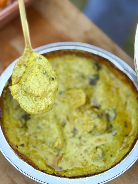 istock Image of serving spoon scooping Indian chicken korma from aluminium takeaway container, creamy curry, Indian cuisine 2224205297