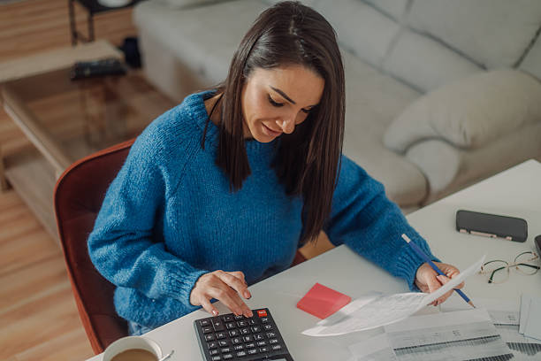 istock Woman managing home finances using calculator and documents 2224206323