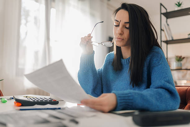 istock Accountant reviewing financial documents at home office: analyzing bills and taxes 2224206325