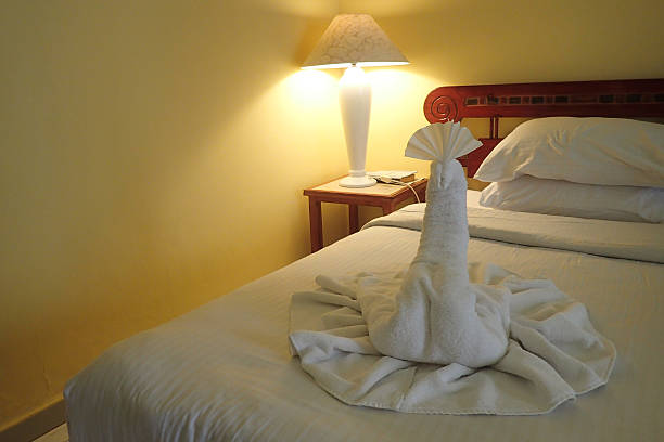 Hand-folded towel decorated with leaves and flowers in the shape of an elephant on the hotel bed.