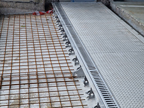 istock Construction of a concrete floor at the underground garage. Reinforcement grid and drainage gutters are currently being installed. 2224207398