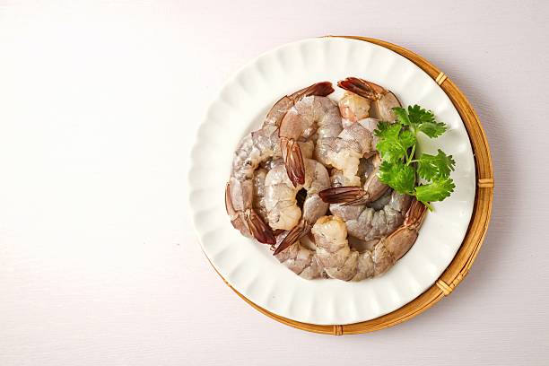 istock Peeled fresh shrimp in white plate on white background 2224210021