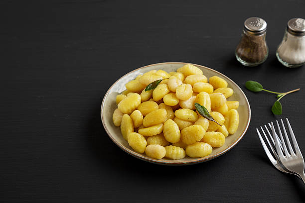 istock Homemade Easy Potato Gnocchi on a Plate on a black background, side view. Space for text. 2224210186