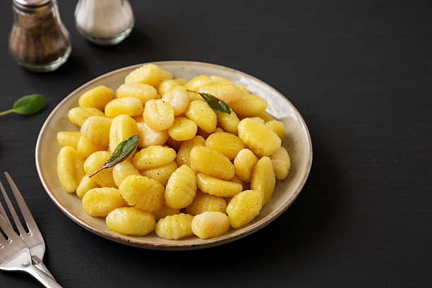istock Homemade Easy Potato Gnocchi on a Plate on a black background, side view. Copy space. 2224210246