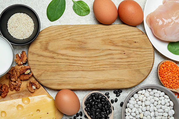Wooden board with word Estrogen and different fresh products on light textured table, flat lay