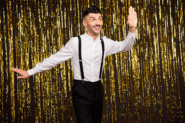 Photo of charming funky young guy dressed glamour outfit looking empty space copyspace dancing isolated shiny golden background