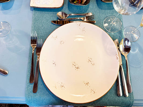 istock Minimalistic image of an empty white plate with fork and knife on a table. Ideal mockup for menu design, food concept, diet visuals, or restaurant branding 2224222044