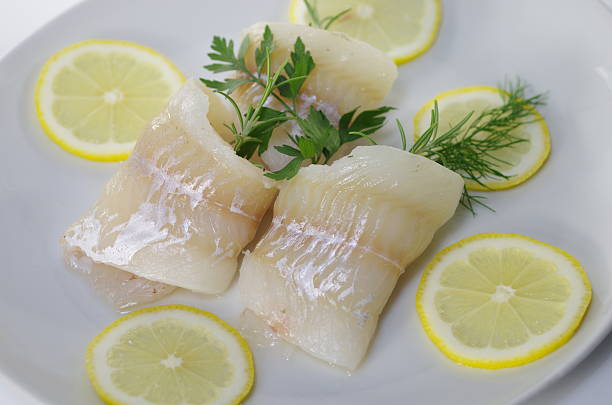 istock fresh raw cod fish fillet on a plate with parsley and lemon 2224222220