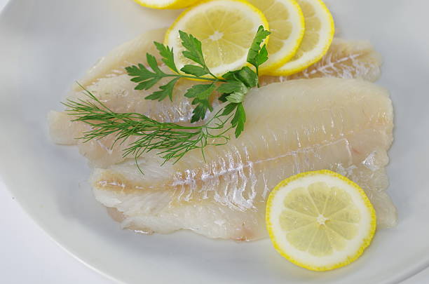 istock fresh raw cod fish fillet on a plate with parsley and lemon 2224222292