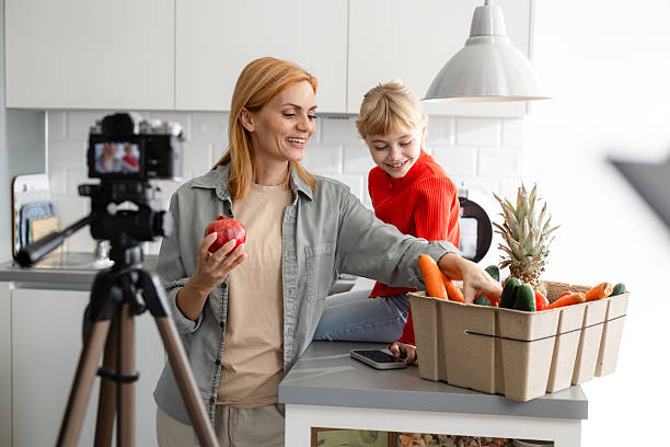istock Mother and daughter creating cooking content together in a modern, bright kitchen 2224222314