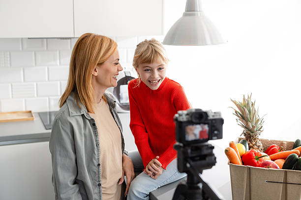 istock Mother and daughter creating cooking content together in a modern, bright kitchen 2224222316