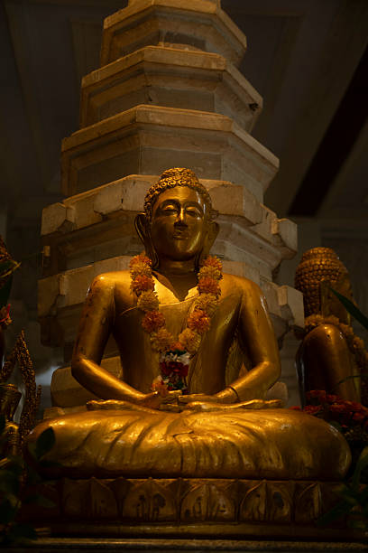 Dark interior with Budha statue sitting in lotus pose. Statue in a buddhist temple monastery in the mountains near Lovina in North Bali.