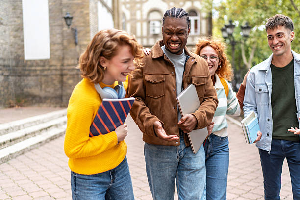 istock Cheerful university students walking and talking together on campus 2224228520