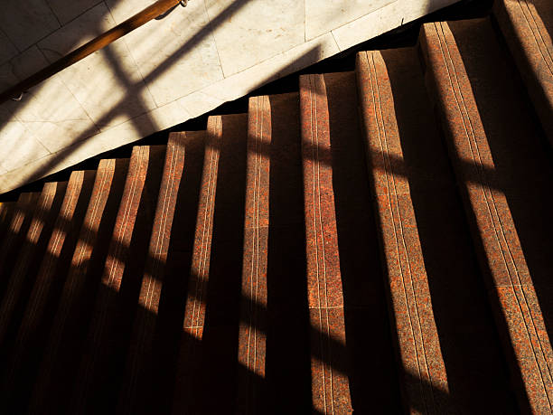 istock Staircase with shadow patterns in a well-lit interior space during daytime hours 2224231270