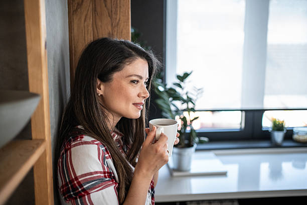 istock Serene woman enjoying a cup of coffee in a modern kitchen 2224232004