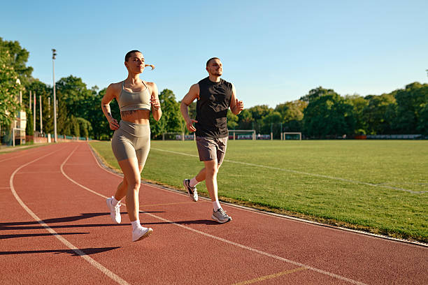 istock Couple jogging on sunny track, active outdoor morning workout 2224232416