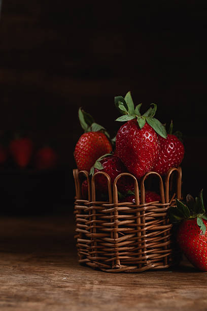 istock Wicker basket with sweet red strawberries on a rustic wooden background. 2224232837