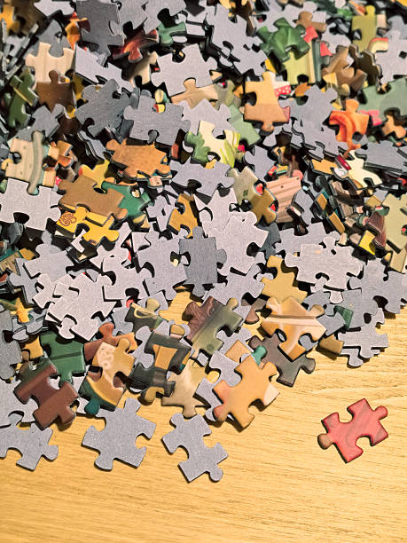 istock Colorful jigsaw puzzle pieces scattered on a wooden surface 2224235679