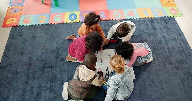 istock Above, education and drawing with kids in classroom for child development, artwork and creative project. Youth, academy and growth with students at school for knowledge, learning and kindergarten 2224235799