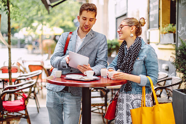 istock Friends are sharing a tablet in a sidewalk cafe 2224235832