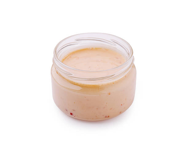 istock Homemade sauce in a glass jar on a plain background 2224236173