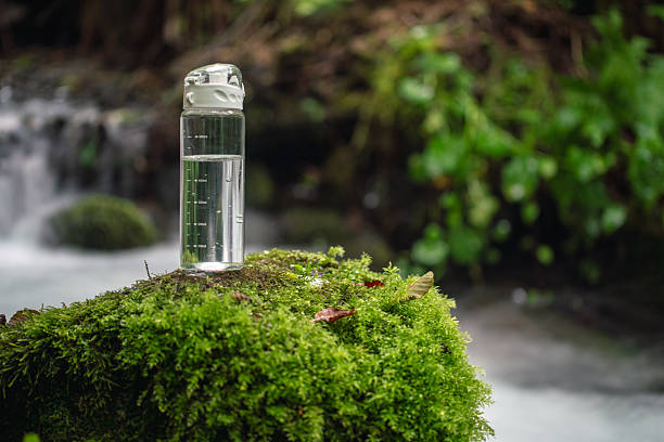 A half-full bottle of drinking water stands on a stone in front of a waterfall. Will we run out of water soon? By the middle of the century the demand for water will increase by around 55 percent worldwide.
