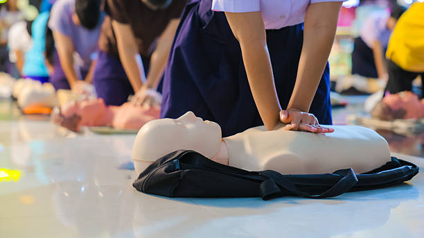 A person performs CPR chest compressions on a during a training session, highlighting essential life-saving techniques and emergency preparedness.