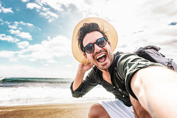 istock Happy young man taking selfie at the beach side - Smiling guy looking at camera outside - Summer vacations and technology concept 2224242343
