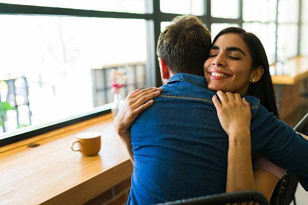 istock Hispanic couple embracing at coffee shop: expressing love and affection 2224253517