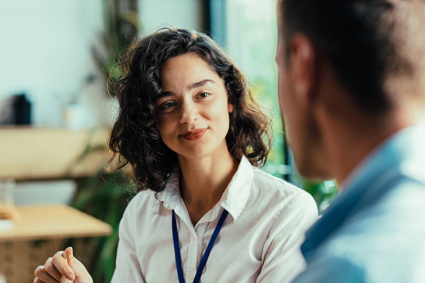 istock Two young coworkers chatting over healthy lunch in bright office cafeteria 2224253739