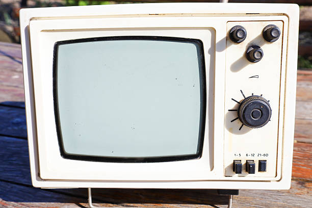 A retro television with a black and white screen displays a classic design and controls. This vintage device is ideal for projects emphasizing nostalgia for past technologies and antique electronics.