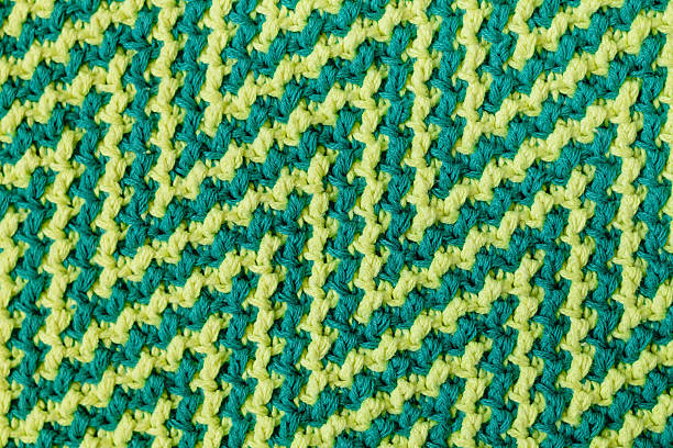 istock Knitted texture with chevron pattern. Texture of mosaic fabric with yellow green geometric ethnic pattern. Crochet mosaic pattern. 2224255473