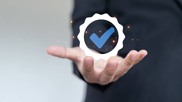 istock Businessman showing verified check mark badge icon for quality assurance, certification, approval, and business guarantee concept on virtual screen. 2224257369