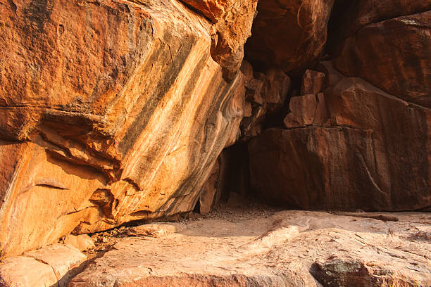 A natural cave formed in weathered sandstone rock.