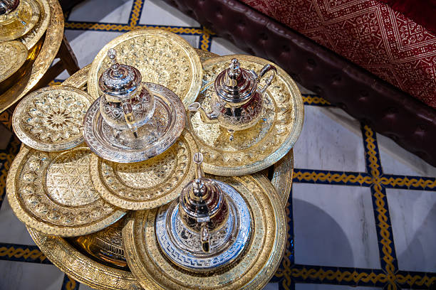 A beautifully crafted traditional teapot and two matching cups showcased on a wooden table with an artistic touch, evoking a sense of sophistication and tradition