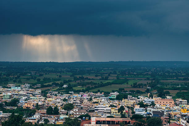 istock Heavy monsoon clouds gather over Badami town, with sunbeams piercing the sky in dramatic rays across the lush landscape. 2224261344