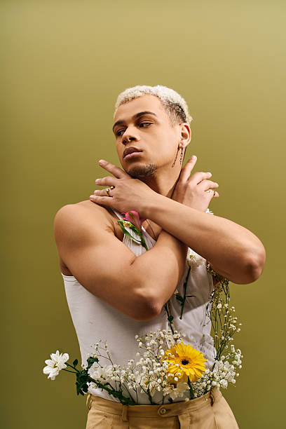 istock Young Black man displays vibrant style amid flowers in a studio setting 2224261396