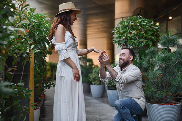Romantic Proposal Scene With Man Proposing And Girlfriend In White Dress is Smiling