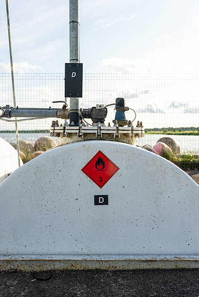 istock Industrial fuel storage tank with warning labels and piping system. 2224265797