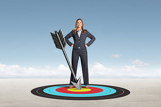 istock Woman Standing Next To Arrow That Has Hit Its Mark 2224266034