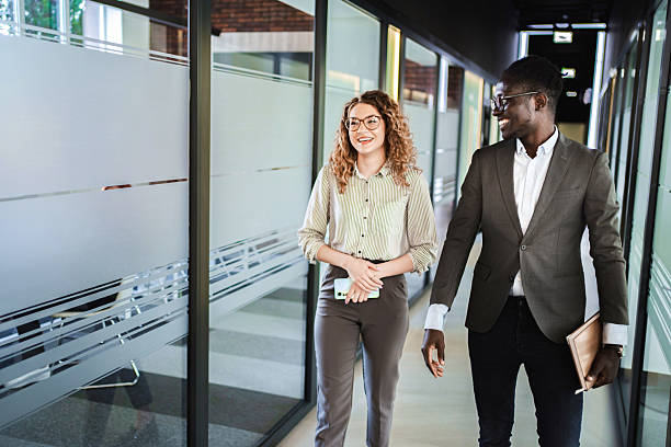istock Businesspeople walking and talking in office corridor 2224267227