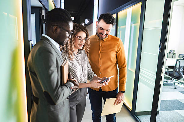 istock Business Colleagues Discussing Project in Office Hallway 2224267408