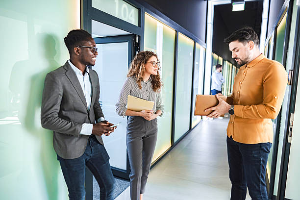istock Businesspeople talking in office corridor during a meeting break 2224268553