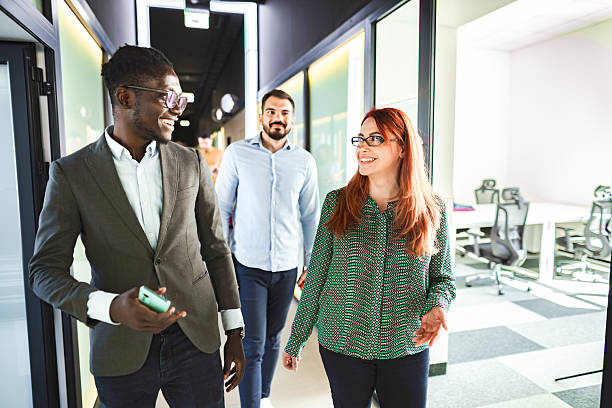 istock Businesspeople walking and talking in office corridor 2224268558