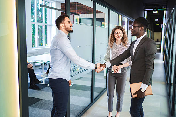 istock Business people shaking hands in office corridor 2224269180