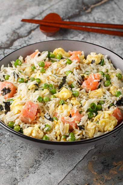 istock Fried rice with vegetables, salmon, egg and seaweed close-up in bowl. Vertical 2224269913