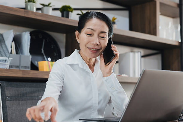 istock Professional woman engages in a phone conversation while working at her desk in a modern office setting during the daytime 2224271965