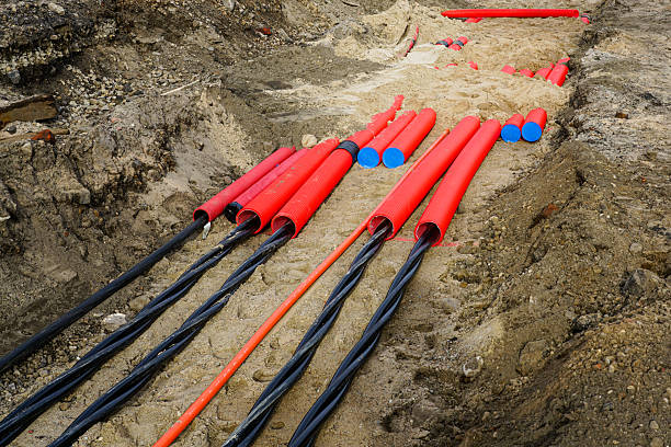 istock Underground Power Cable Installation with Protective Red Conduits at Urban Construction Site 2224272666